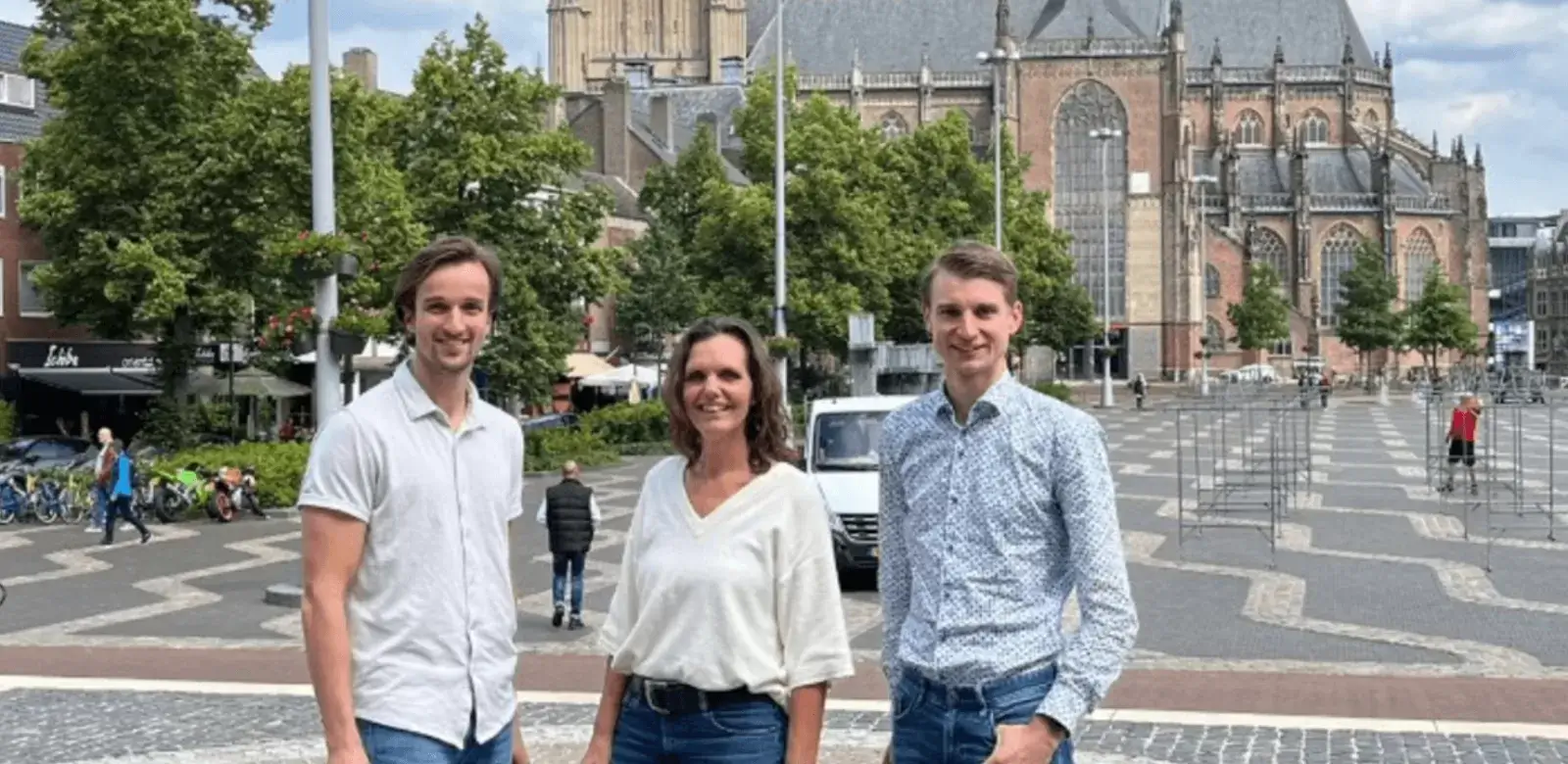 Foto van drie mensen op een groot plein voor een kathedraal